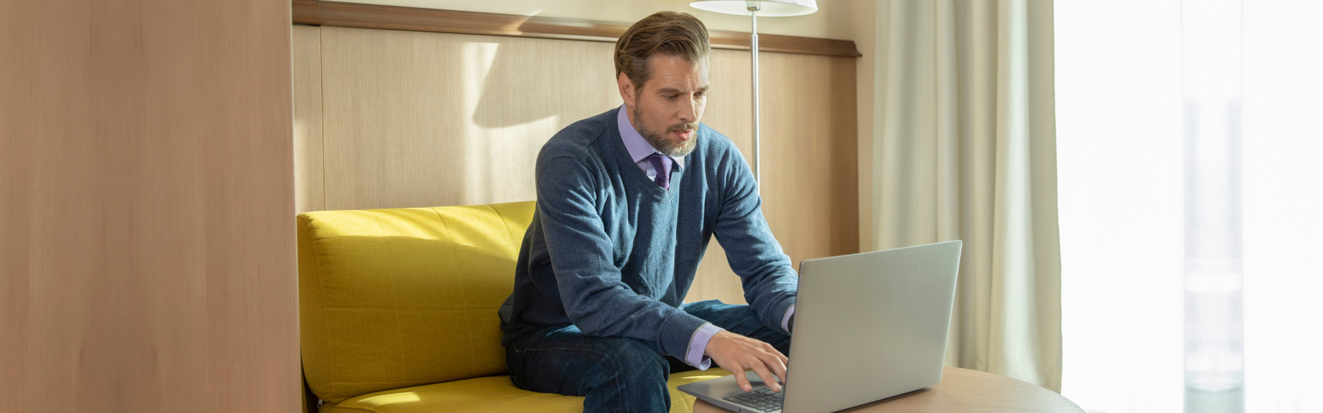 Man working on a notebook in hotel room