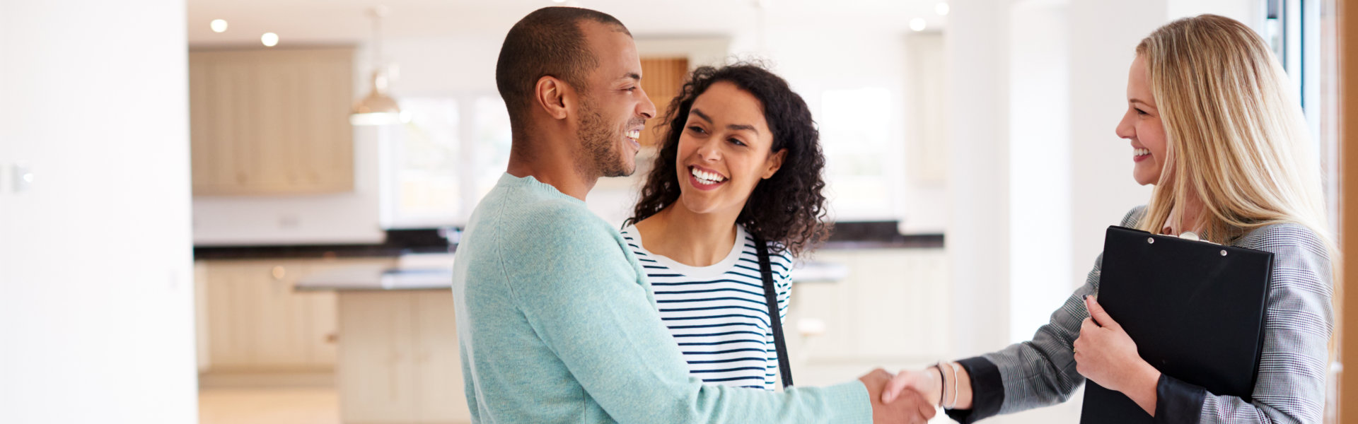 Female Realtor Shaking Hands With Couple Interested renting